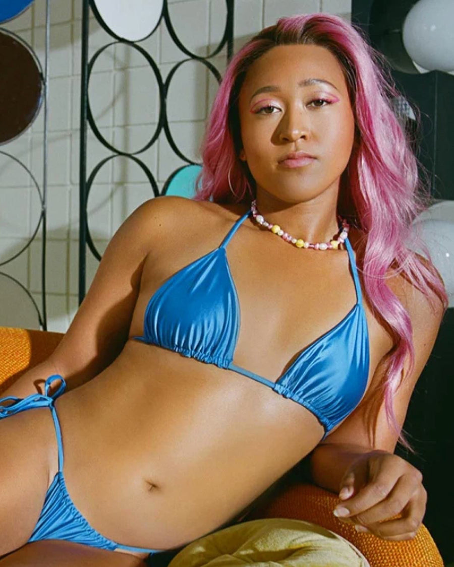 Woman with pink hair in a blue bikini wearing a custom pearl and multicolor beaded necklace