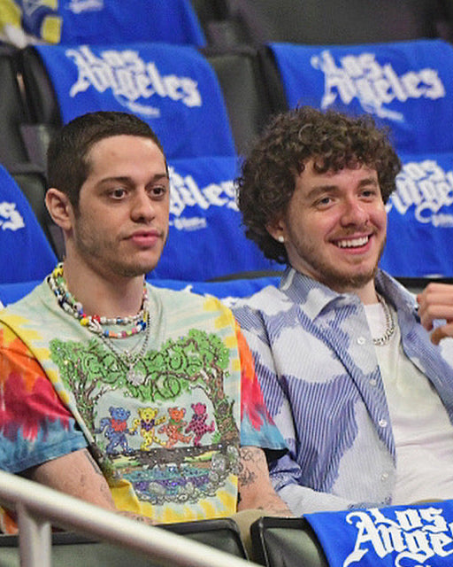 Two men courtside at a basketball game wearing colorful custom beaded charm necklaces