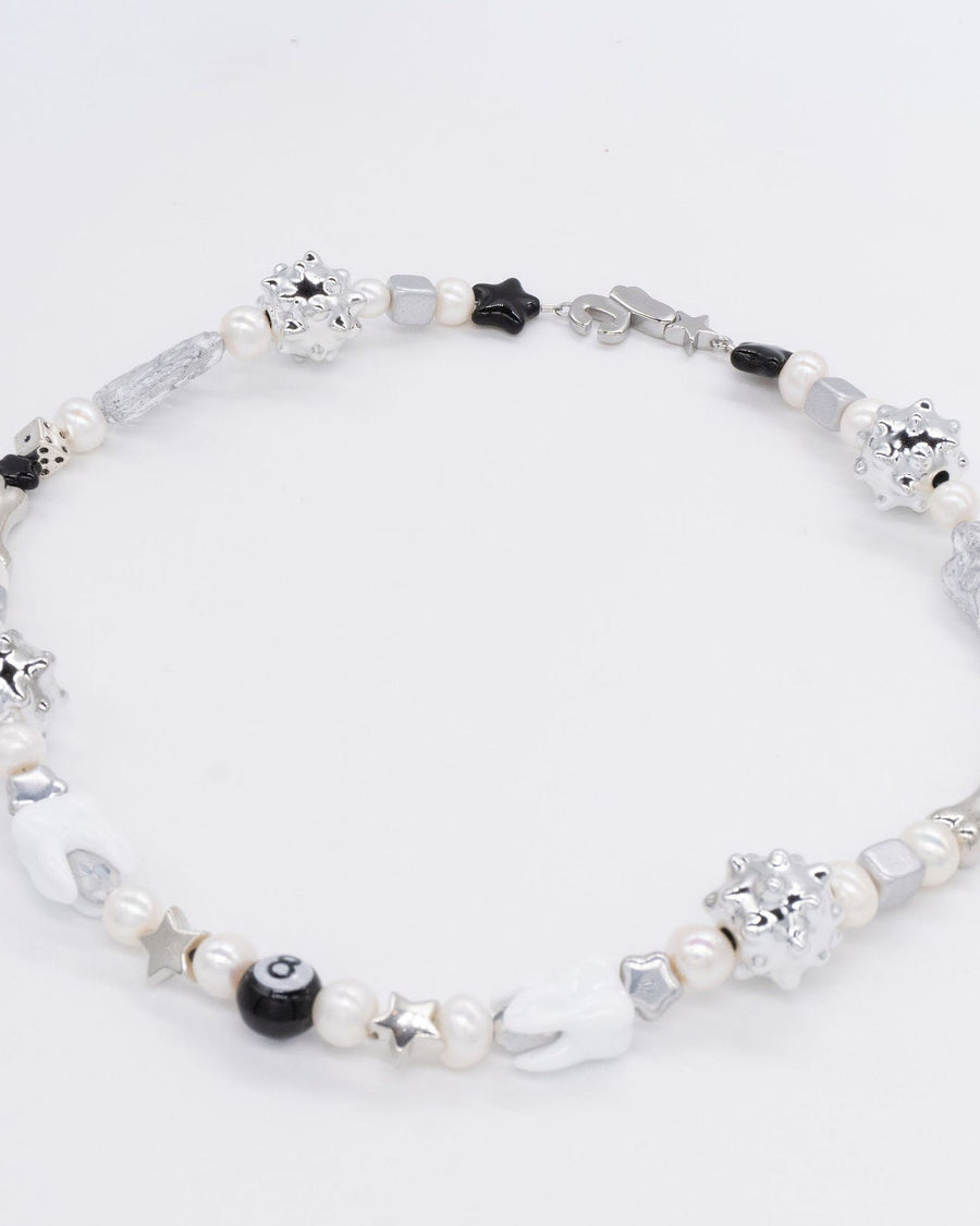 Close-up of the sloane necklace with silver spiky beads, black stars and white pearls