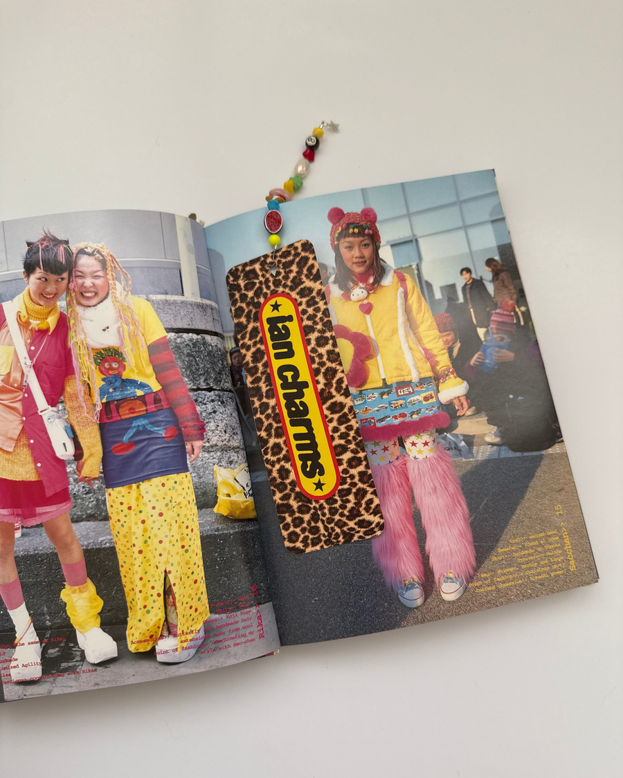 The charms n noble leopard bookmark resting on an open street-style photo book