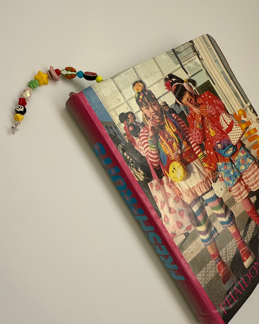 Leopard ian charms bookmark with a colorful beaded tail tucked into a fashion photo book
