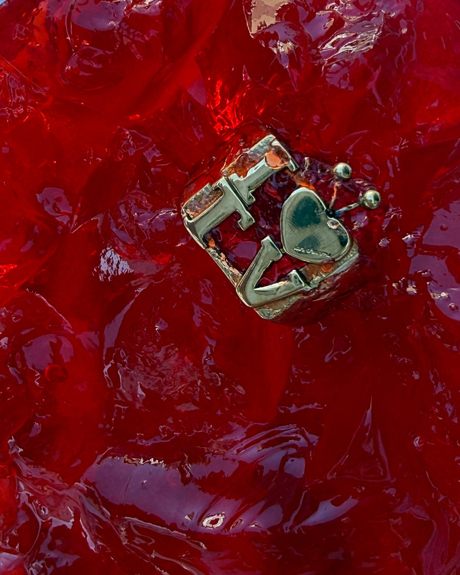 I heart TV ring with a green enamel heart on shiny red crumpled cellophane – the intellectual ring