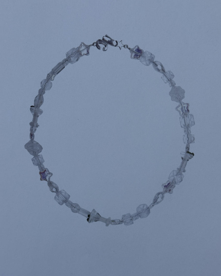 The usual clear crystal bead necklace on a dusty blue background