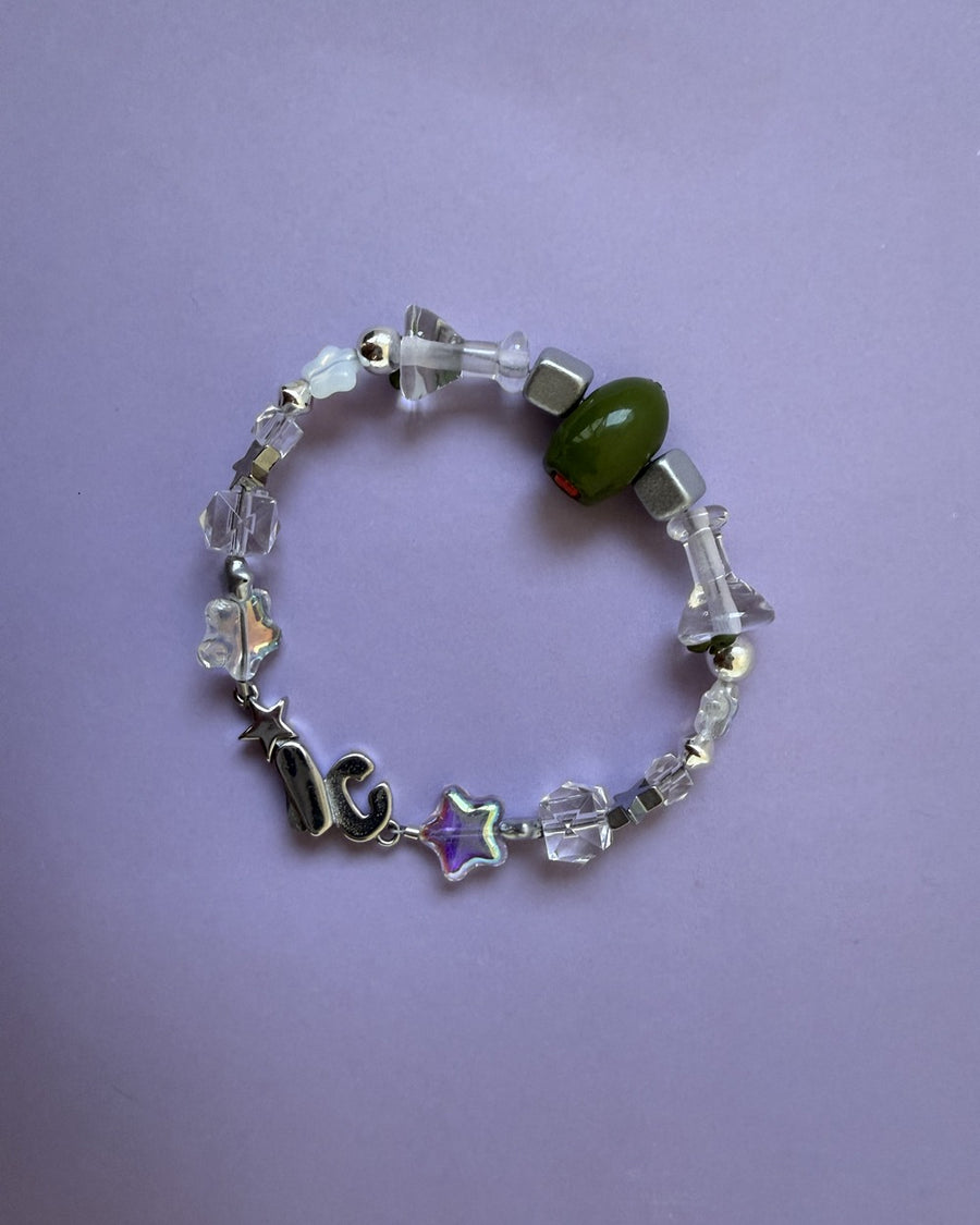 The usual bracelet with clear crystal beads and a green olive bead on a lilac background
