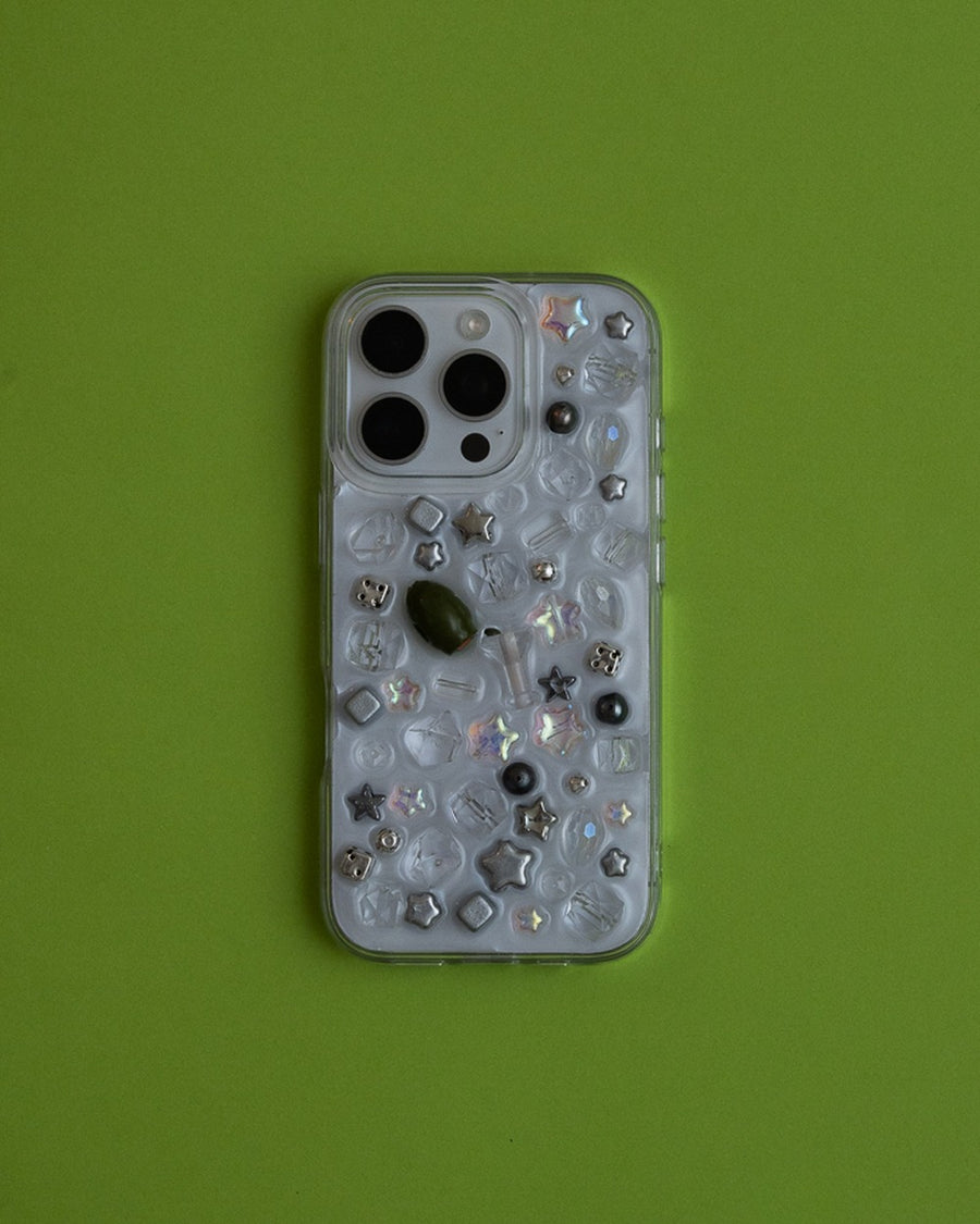 Clear beaded usual phone case with silver star and crystal charms on a lime green background