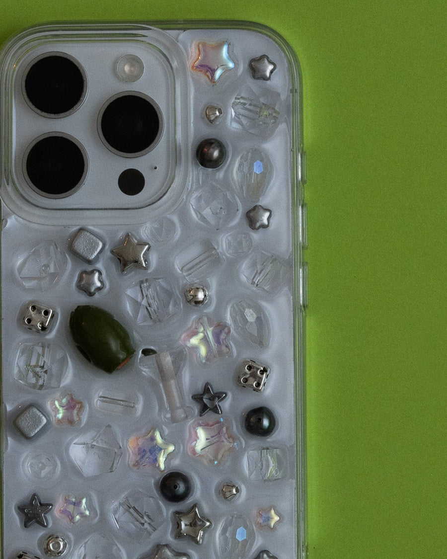 Close-up of the usual phone case's crystal, silver star and green olive charms