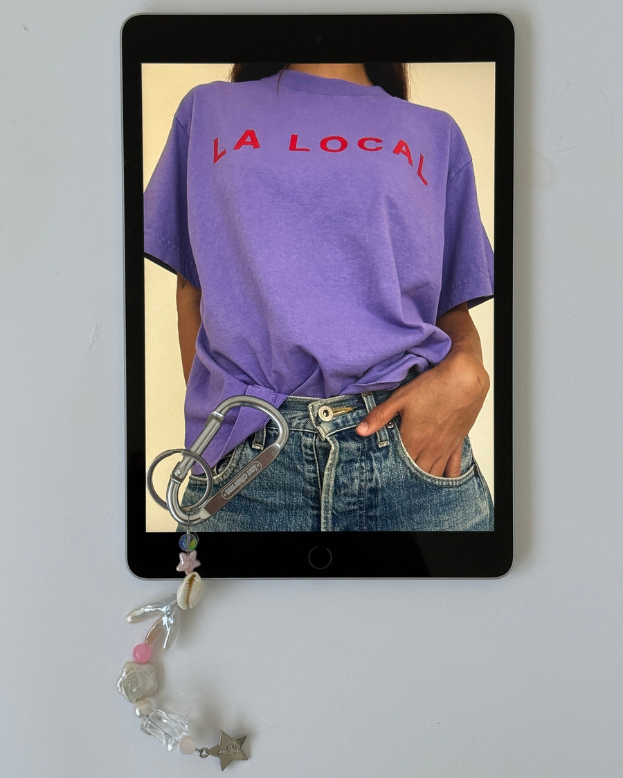 Tablet showing a person in the purple la local tee with the marlee keychain clipped to their jeans