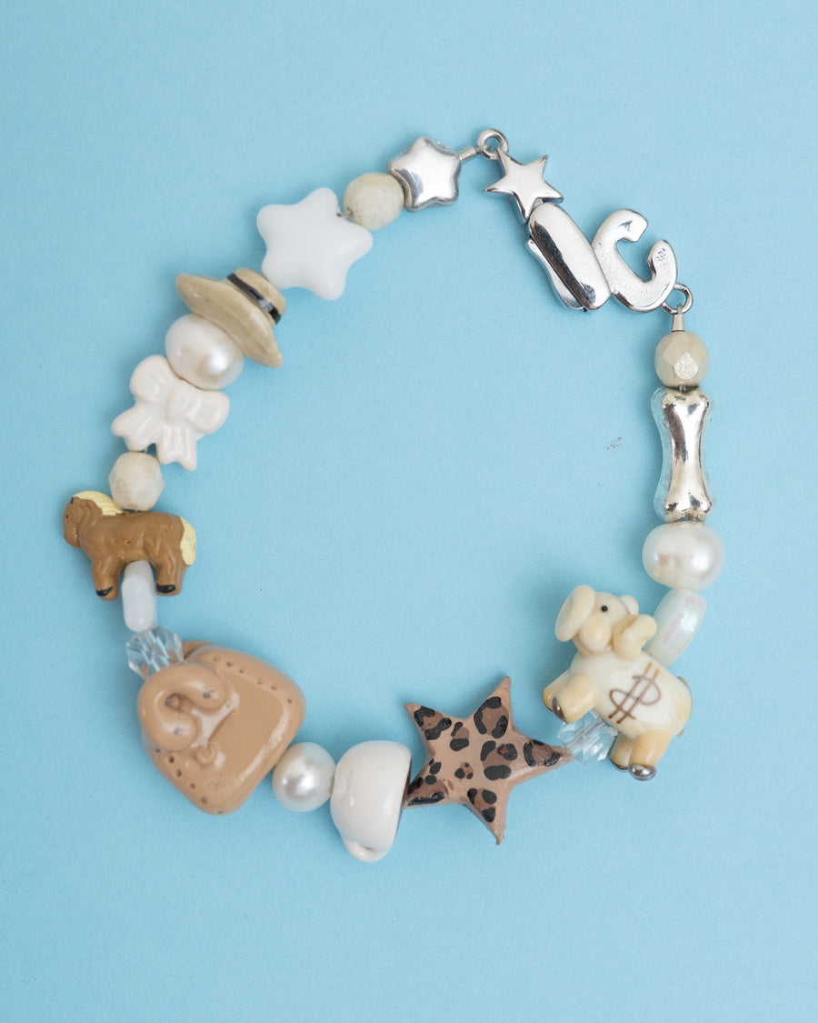 Neutral bracelet with pearls, white flowers, bones, horse, a leopard star and piggy bank beads – the quiet lux bracelet by Ian Charms