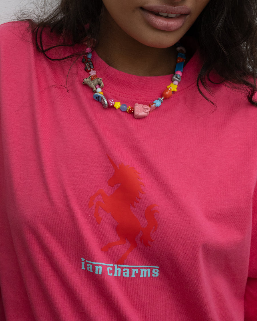 Close-up of the la necklace worn with a hot pink Ian Charms unicorn tee
