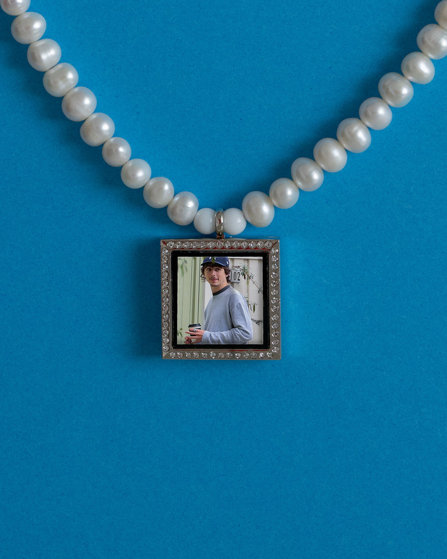 Silver square photo pendant with a custom picture on a freshwater pearl necklace, blue background