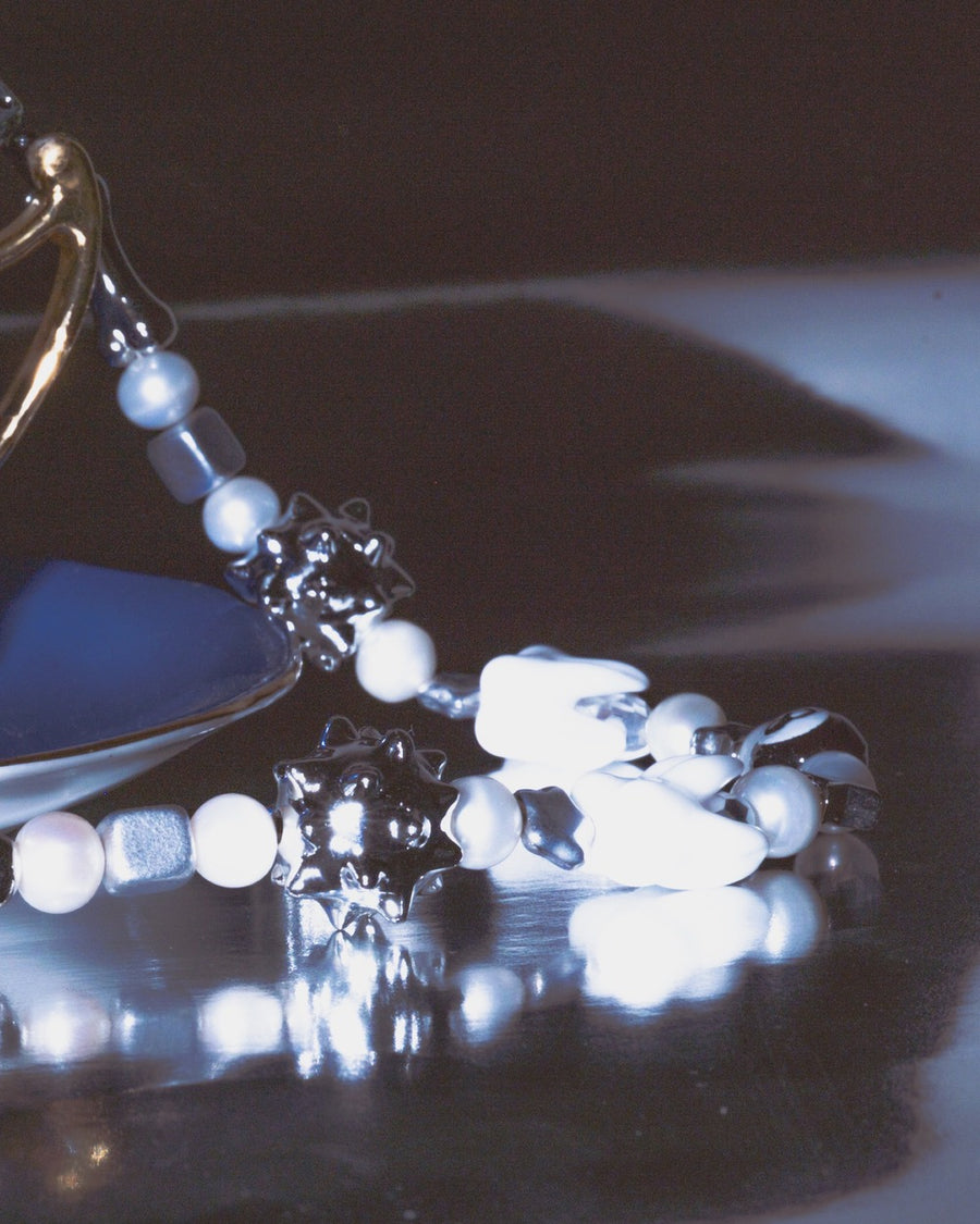 Moody close-up of the sloane necklace's pearls and silver spiky beads in low light
