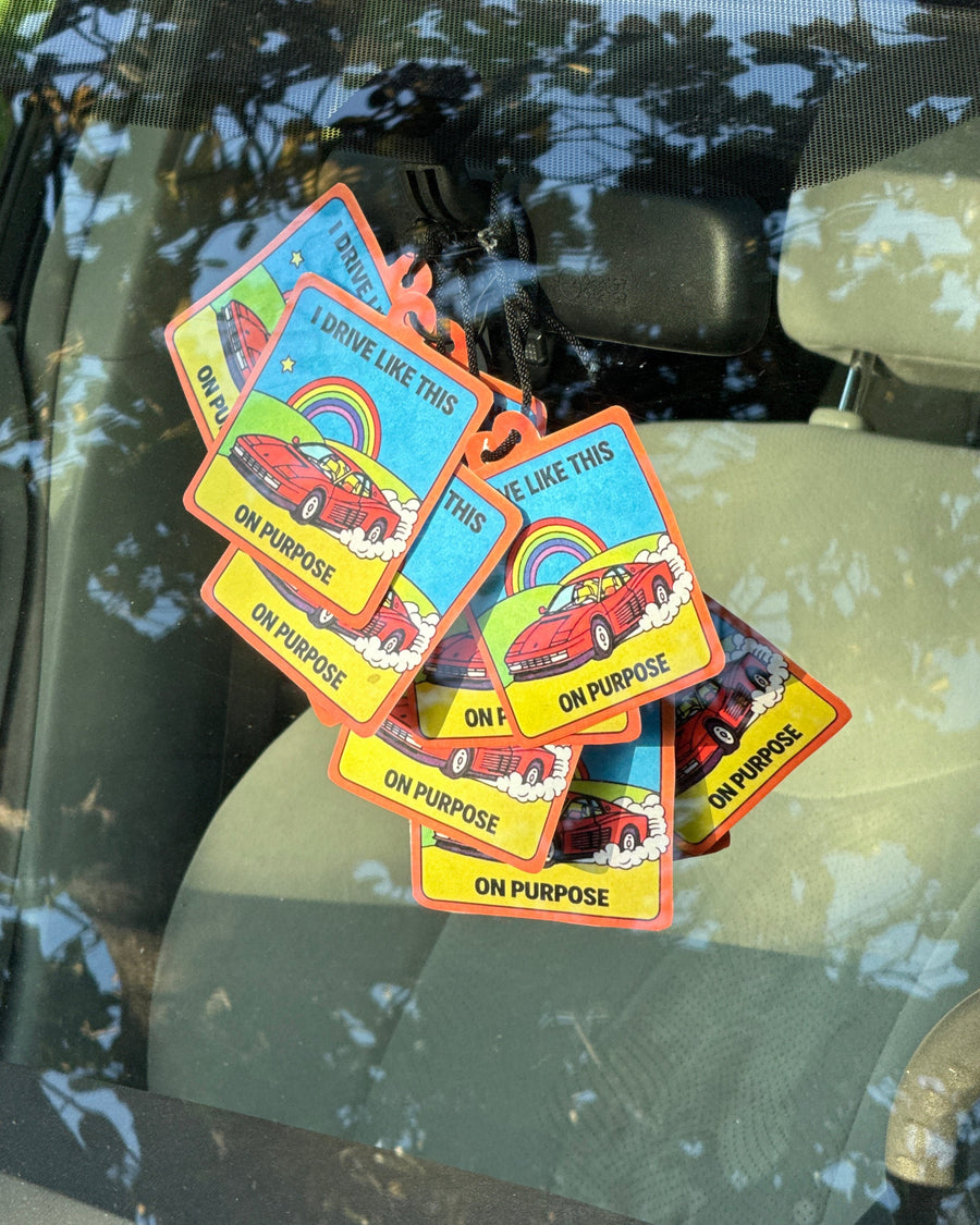 Stack of worst driver car air fresheners hanging inside a car window