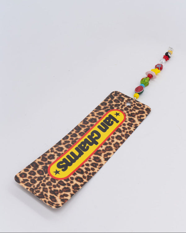 Leopard print bookmark with a yellow ian charms logo and a beaded charm – the charms n noble bookmark
