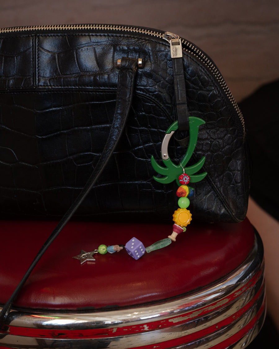 Green palm tree carabiner with mermaid, dice, sun, fish, margarita, chameleon beads clipped to a black croc handbag – the club mid keychain