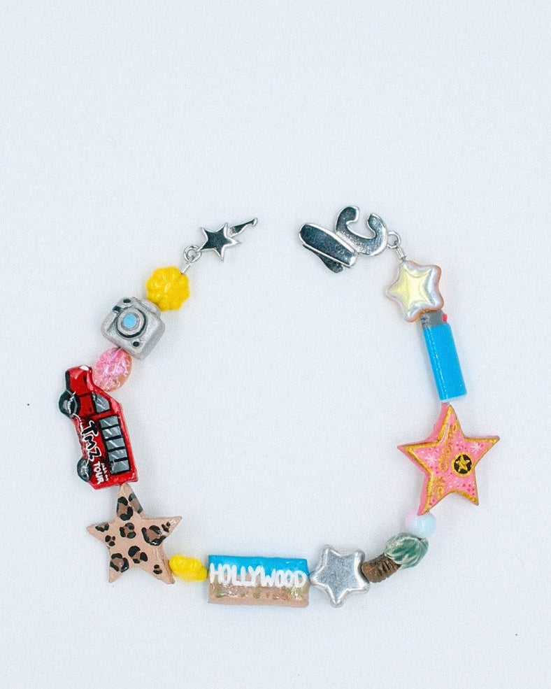 Beaded bracelet with a red tour bus, gold star, palm tree, camera, leopard star and LA sign beads – the LA bracelet by Ian Charms