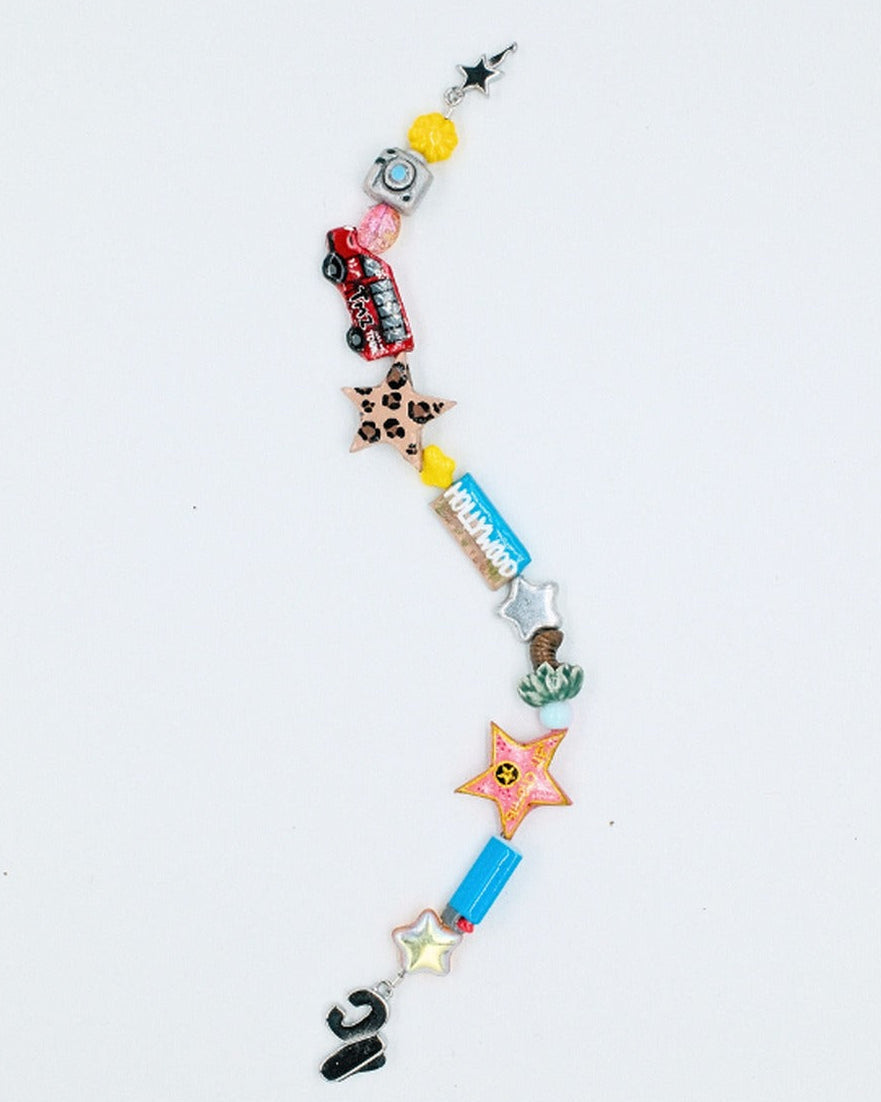 The LA bracelet laid out straight showing tour bus, leopard, sunscreen tube and gold star beads