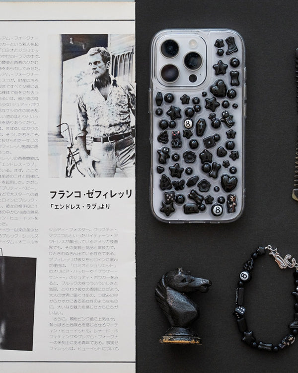 Clear iPhone case covered in black beads beside a black beaded bracelet and horse figurine – the smoker phone case