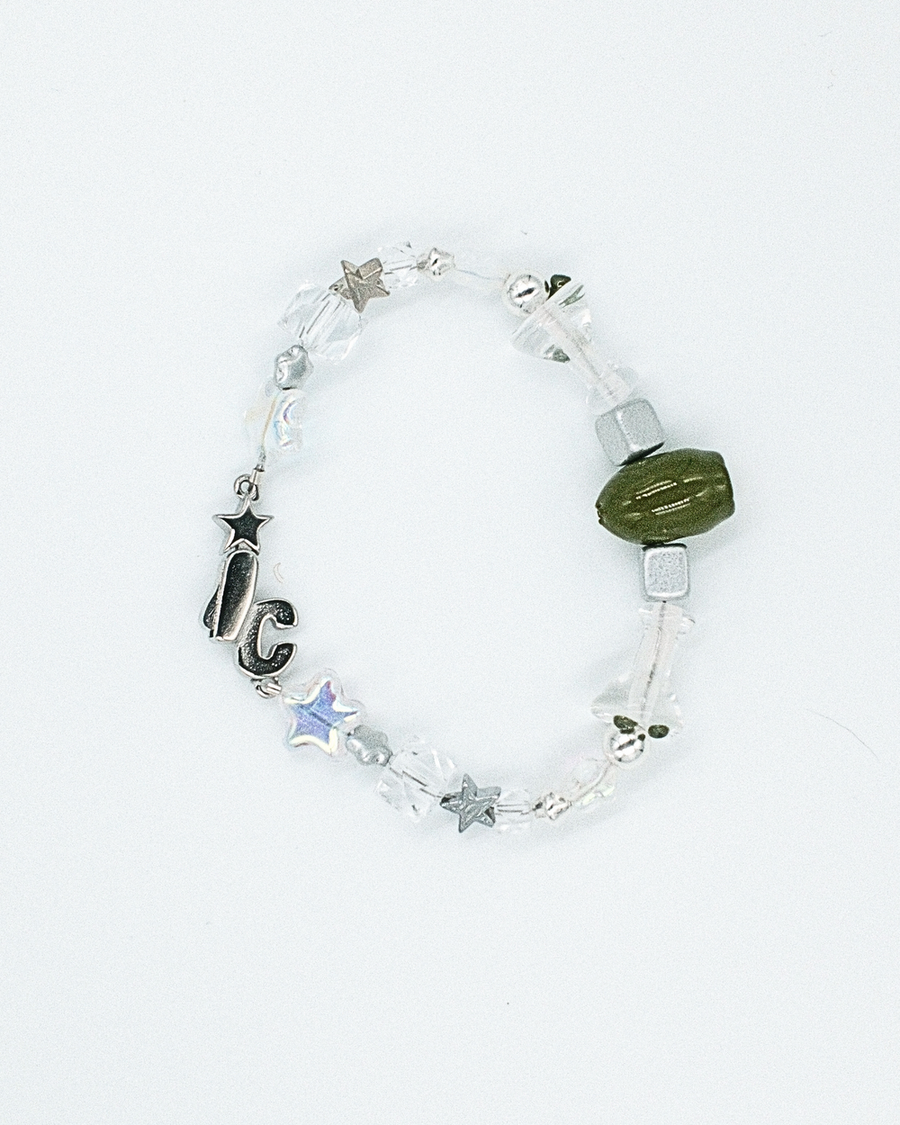 Clear and silver beaded bracelet with a green olive bead and black IC charm – the usual bracelet