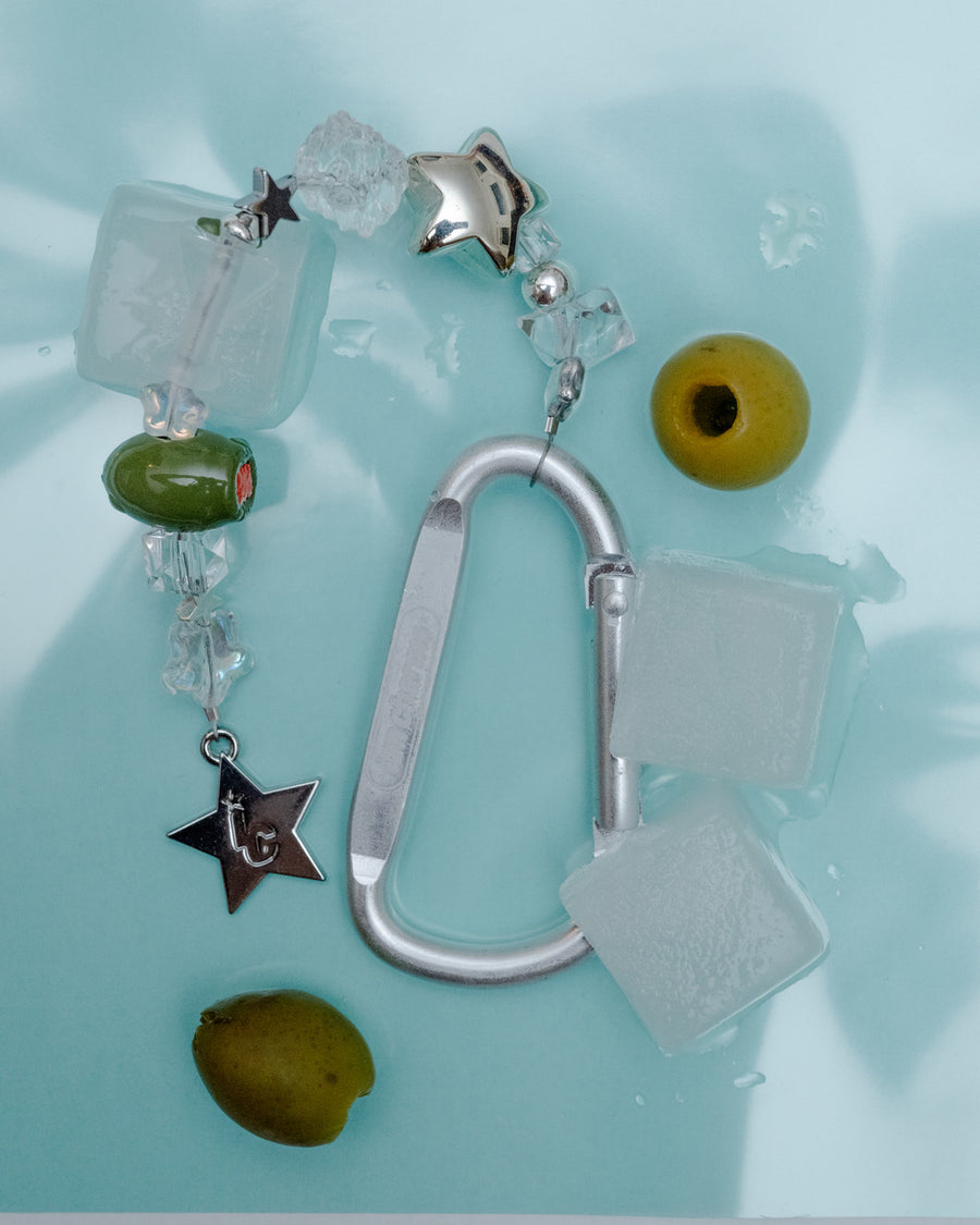 Carabiner keychain with clear crystal beads, a green olive bead and star charm among ice and olives – the usual keychain